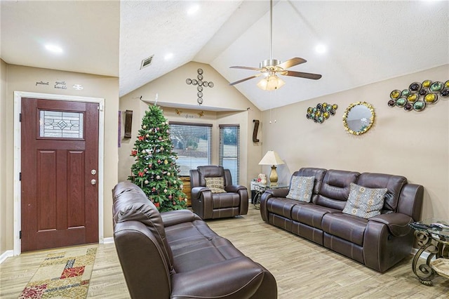 living room featuring ceiling fan, lofted ceiling, and light hardwood / wood-style flooring