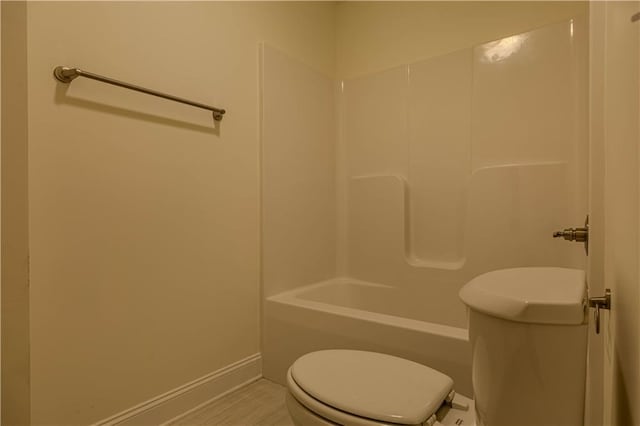 bathroom featuring toilet, bathtub / shower combination, and wood-type flooring