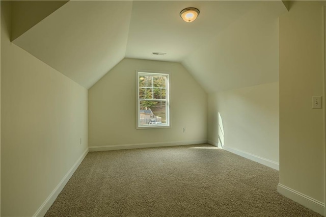 bonus room with vaulted ceiling and carpet floors