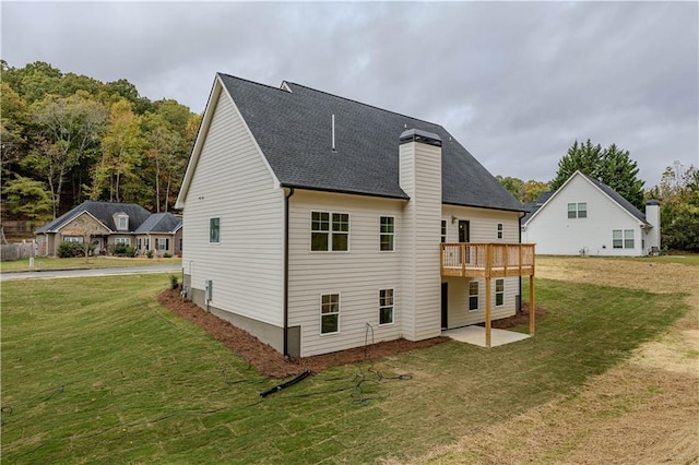 rear view of property with a patio, a deck, and a lawn