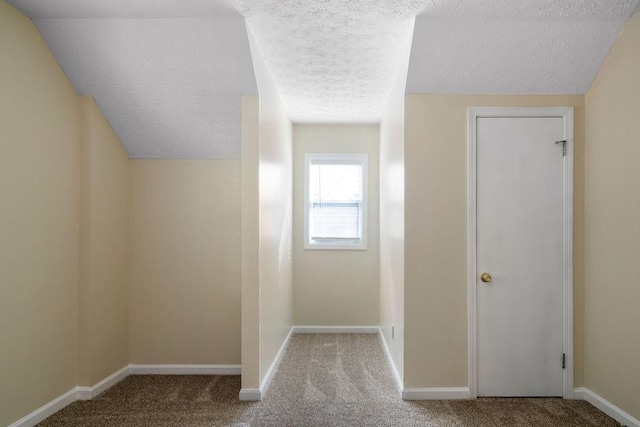 hallway with a textured ceiling and carpet floors