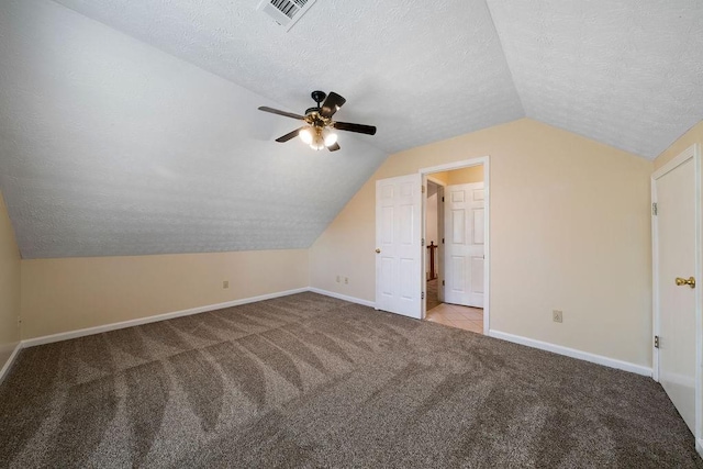 bonus room featuring a textured ceiling, ceiling fan, vaulted ceiling, and light colored carpet