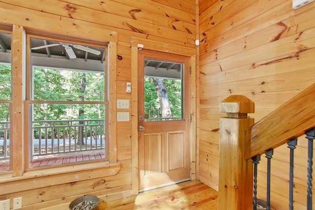 doorway featuring wood walls and light wood-type flooring