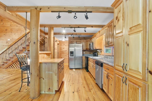 kitchen with appliances with stainless steel finishes, light hardwood / wood-style flooring, butcher block countertops, and sink