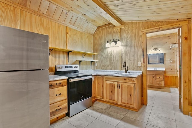 kitchen with vaulted ceiling with beams, light tile patterned floors, wood walls, stainless steel appliances, and sink