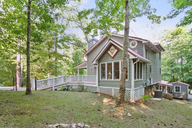 exterior space featuring an outbuilding, a yard, and a wooden deck