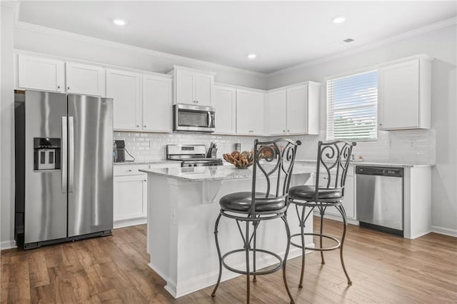 3135 Ellenton Dr, Lithia Springs, GA 30122 - kitchen featuring light stone countertops, stainless steel appliances, white cabinetry, and wood finished floors