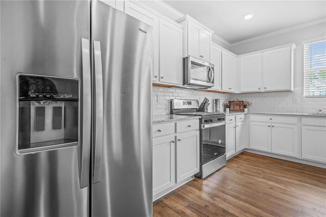 3135 Ellenton Dr, Lithia Springs, GA 30122 - kitchen featuring ornamental molding, light stone countertops, stainless steel appliances, and white cabinetry