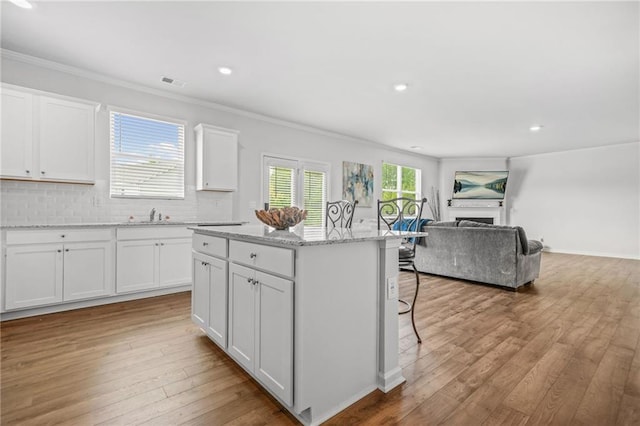 3135 Ellenton Dr, Lithia Springs, GA 30122 - kitchen with visible vents, ornamental molding, open floor plan, and a center island