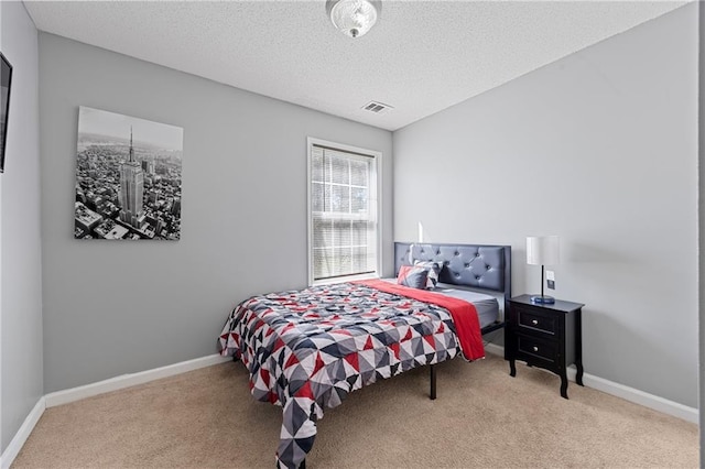 carpeted bedroom with visible vents, a textured ceiling, and baseboards