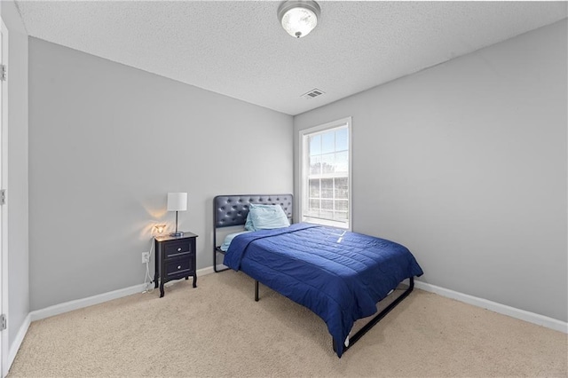 carpeted bedroom with baseboards, visible vents, and a textured ceiling