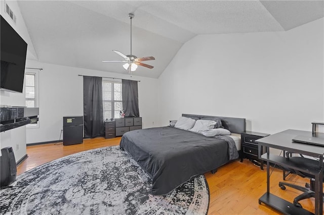 bedroom featuring lofted ceiling, visible vents, ceiling fan, and light wood finished floors