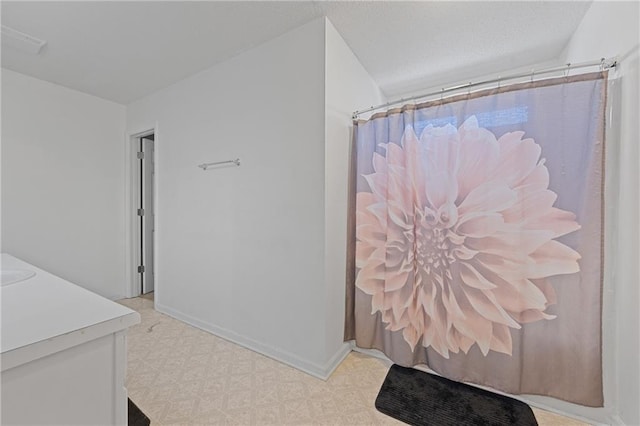 full bath featuring curtained shower, vanity, baseboards, and tile patterned floors