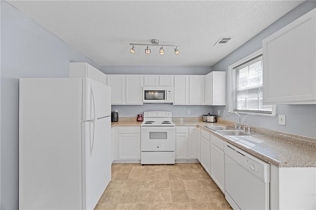 kitchen featuring white appliances, visible vents, a sink, and white cabinetry