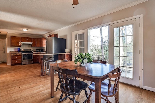 dining room with crown molding, light hardwood / wood-style floors, and a healthy amount of sunlight