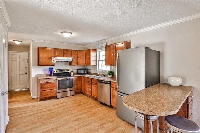 kitchen featuring sink, ornamental molding, light hardwood / wood-style floors, and appliances with stainless steel finishes