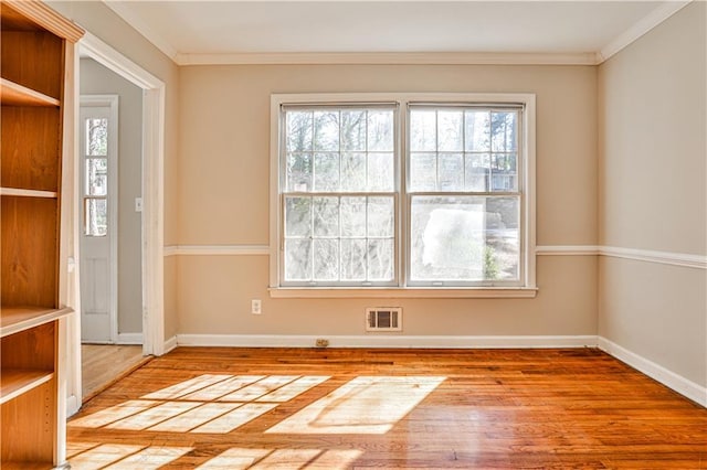 spare room featuring crown molding and wood-type flooring