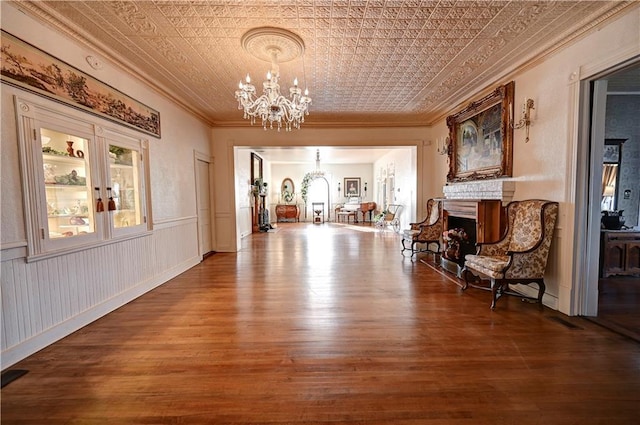 unfurnished dining area featuring crown molding, an inviting chandelier, and hardwood / wood-style flooring