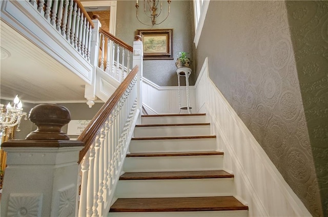 staircase with a notable chandelier