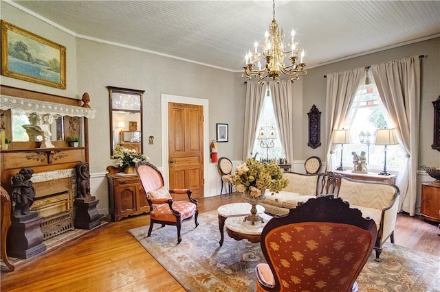 sitting room with crown molding, a notable chandelier, and light wood-type flooring