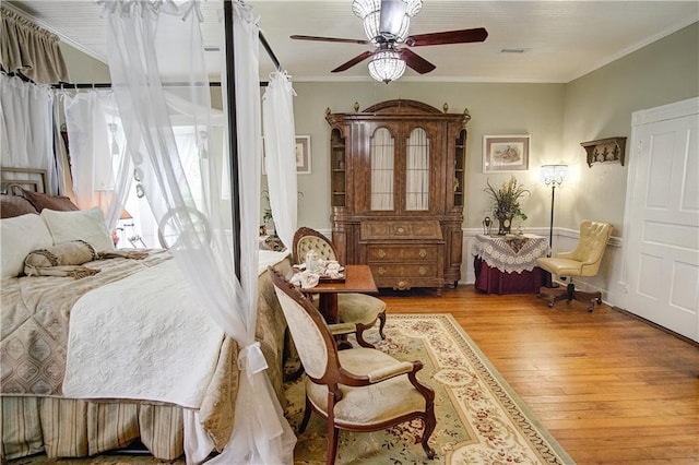 bedroom featuring ceiling fan, crown molding, and light hardwood / wood-style flooring