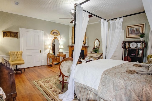 bedroom featuring ceiling fan, hardwood / wood-style flooring, and crown molding