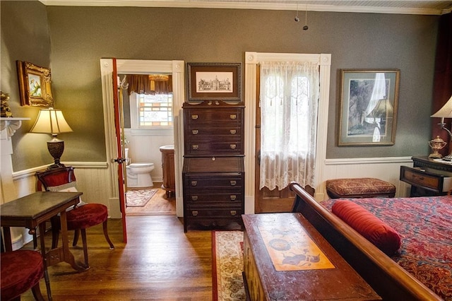 bedroom featuring crown molding, connected bathroom, and hardwood / wood-style floors