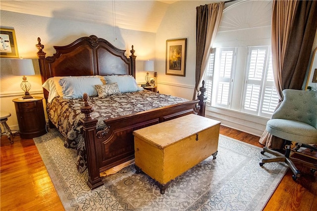 bedroom featuring vaulted ceiling and wood-type flooring