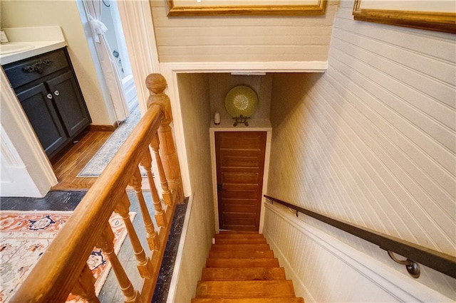 stairs featuring hardwood / wood-style floors and sink