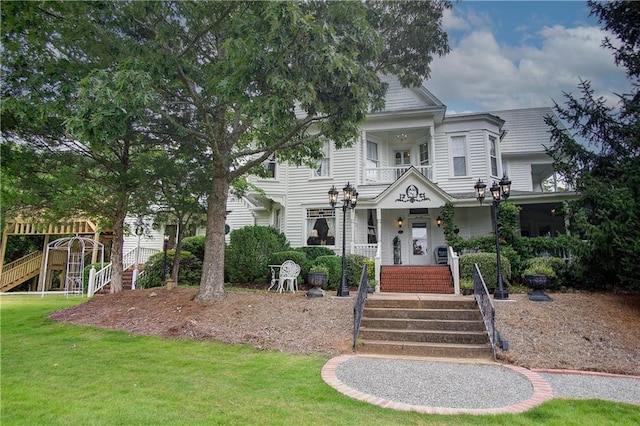 view of front of property with a front lawn and a balcony