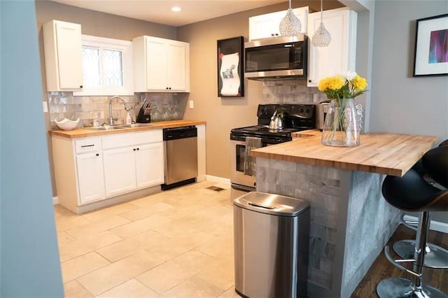 284 Barfield Ave SW, Atlanta, GA 30310 - kitchen with stainless steel appliances, wood counters, a breakfast bar area, a sink, and recessed lighting