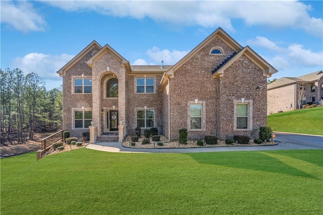 view of front of property with brick siding and a front lawn