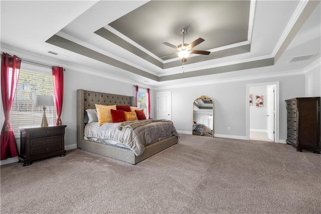 bedroom featuring baseboards, visible vents, a tray ceiling, crown molding, and carpet flooring