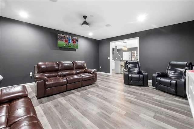 home theater featuring a ceiling fan, light wood-style flooring, and baseboards