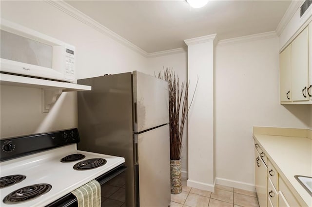 kitchen featuring range with electric cooktop, white microwave, cream cabinets, light countertops, and crown molding