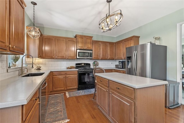 5415 Fieldfreen Dr, Cumming, GA 30028 - kitchen with appliances with stainless steel finishes, a sink, brown cabinetry, and wood finished floors