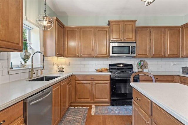 5415 Fieldfreen Dr, Cumming, GA 30028 - kitchen featuring stainless steel appliances, a sink, dark wood-type flooring, brown cabinets, and light countertops