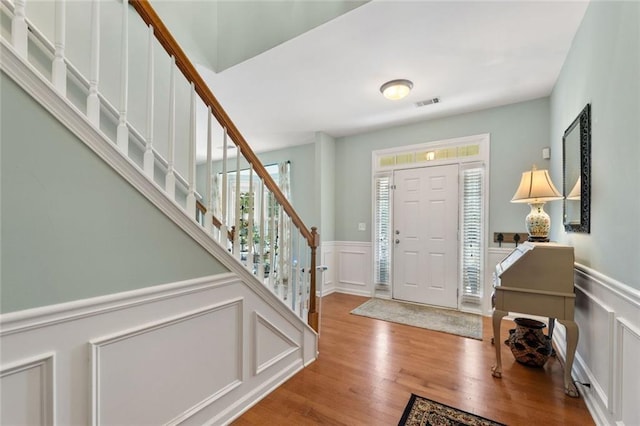 5415 Fieldfreen Dr, Cumming, GA 30028 - entryway featuring a decorative wall, a wainscoted wall, stairway, and wood finished floors