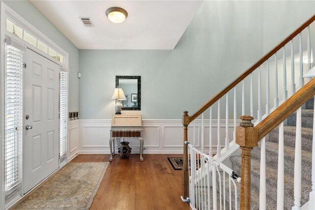 5415 Fieldfreen Dr, Cumming, GA 30028 - entryway featuring hardwood / wood-style floors, a wainscoted wall, stairway, and a decorative wall