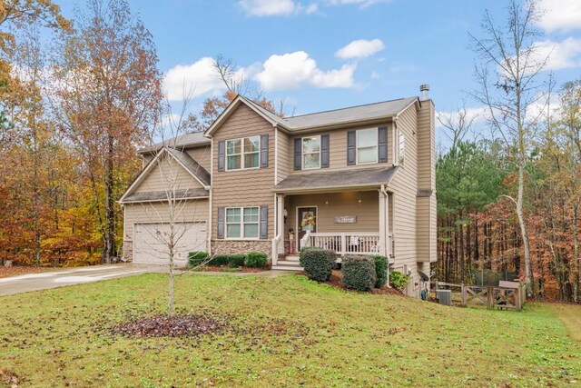 view of front of house featuring covered porch, a garage, and a front lawn