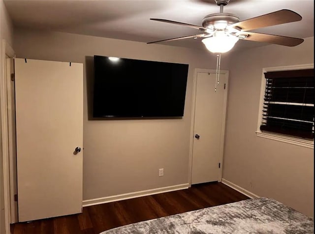 unfurnished bedroom featuring ceiling fan, baseboards, and wood finished floors