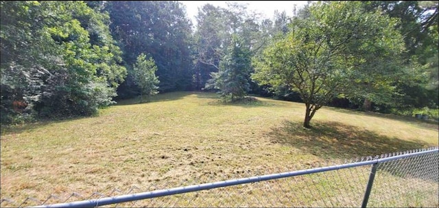 view of yard with a forest view and fence