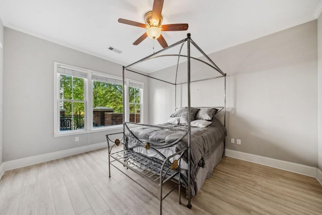 bedroom with ceiling fan, light wood-type flooring, and ornamental molding