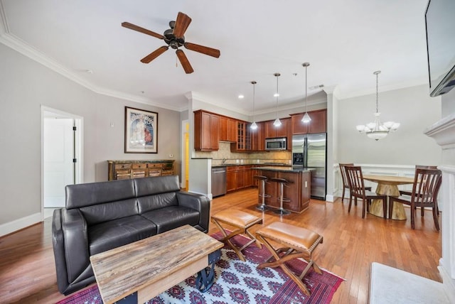 living room with ornamental molding, ceiling fan with notable chandelier, and light wood-type flooring