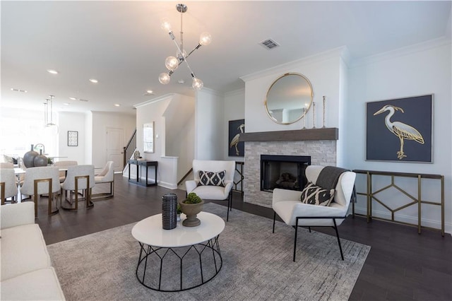 living room with dark wood-style flooring, a fireplace, visible vents, and crown molding