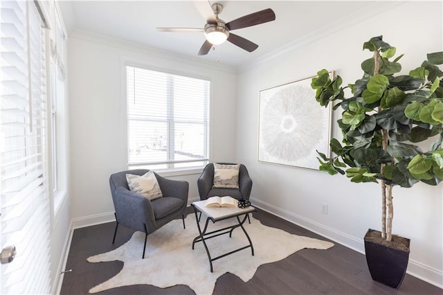 living area with dark wood finished floors, crown molding, baseboards, and ceiling fan