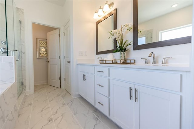 bathroom featuring marble finish floor, a marble finish shower, double vanity, a sink, and baseboards