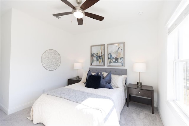 bedroom featuring light colored carpet, ceiling fan, and baseboards