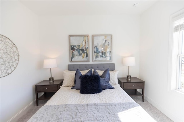 bedroom with baseboards and light colored carpet