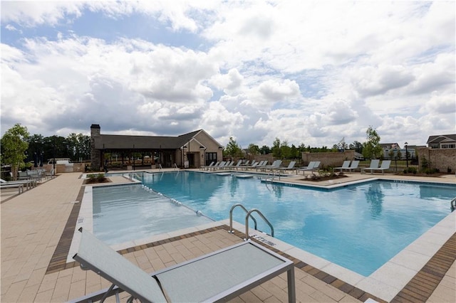 pool with a patio and fence